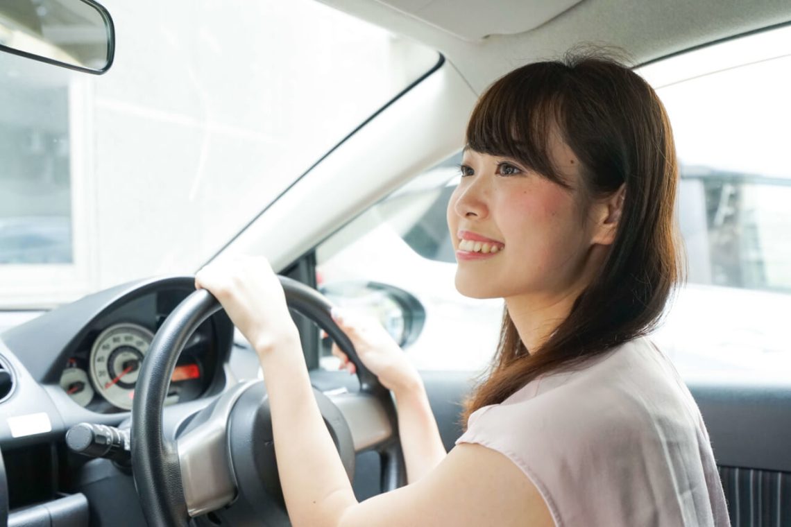 レンタカーを借りて運転する女性