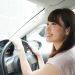レンタカーを借りて運転する女性